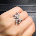 Bague élégante en argent avec nœud serti de micro-zircones portée au doigt - US 6 / Or blanc