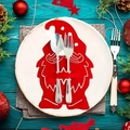 Porte-couverts de Noël en feutre rouge avec cuillère et fourchette sur fond festif - Pièce Unique / Père Noël Rouge