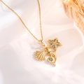 Macro shot of gold necklace with starfish shell and dolphin charms on white silk - Gold Starfish & Shell