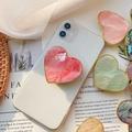 Supporto per telefono a cuore rosa con trama a conchiglia e bordo dorato su fondo bianco - Impugnatura Cuore Oro / Conchiglia di Capasanta Rossa