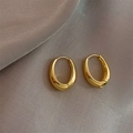 Minimalistische goldene ovale Creolen im Vintage-Stil auf elegantem beigen Seidenhintergrund - Gold