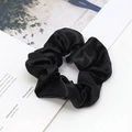 Elegante elastico per capelli in raso nero su sfondo minimalista tipo rivista - Nero