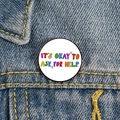 Macro shot of 'IT'S OKAY TO ASK FOR HELP' enamel pin on blue denim fabric background - XZ4796-It's Okay To Ask For Help