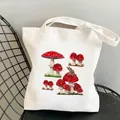 White canvas tote bag featuring frog and red mushroom illustration on a metal chair - C2-Red Mushroom & Frog (No Zipper No Pocket)