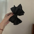 Elegant large black satin bow hair claw clip held by hand in a minimalist setting - Black Double-sided Bow (1#)