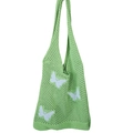 Dettaglio della borsa tote all'uncinetto verde con farfalla bianca e maglia a traforo - verde chiaro