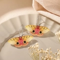 Colorful yellow and pink moth dangle earrings in acrylic resin on a white ceramic tray - Black Eyes Yellow Butterfly Earrings (Eye-spot Pattern)
