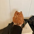 Brown drawstring bucket bag with quilted pocket and camellia metal charm detail - Brown