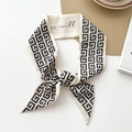 Elegant beige silk ribbon scarf with Greek key pattern and handwritten lettering detail - Geometric Characters