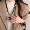 Détail du cordon en tissu léopard et du pendentif étoile noire mate sur un collier - Imprimé Léopard - Étoile