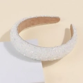 Close-up of white crystal and pearl embellished knotted headband on a beige background - White