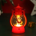Close-up of red vintage Christmas lantern with Santa Claus pattern and warm LED light - Red Santa with Gift