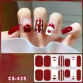 Detailed macro view of Christmas nail stickers featuring Santa and red plaid patterns - CS425