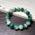 Oriental style bodhi root cat paw bracelet with green and white round beads on wood table - Floating Flower Green Round