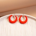 Dettaglio di orecchini a C in acrilico rosso con perni in argento su piatto bianco - Forma a C Rossa (Perno in Argento)