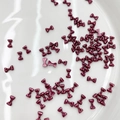Burgundy metallic 3D bow nail art charms displayed on a white polished plate - Pearlescent Burgundy