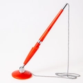 Red desk pen with secure silver metal chain and round adhesive base for office use - Red