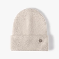 Creamy white ribbed knit beanie with a stylish metal badge for winter warmth - One Size / Beige