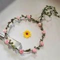 Detail eines rosa Kunstrosen-Blumenkranzes mit grünen Blättern und Reben-Haarband - Rosa