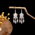 Macro shot of silver ethnic hollow earrings with flower leaf tassels on rustic wood - Silver Hollow Butterfly Snake Bone Tassel Style (E2873-21)