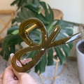 Détail d'une grande pince à cheveux vert olive avec un ressort en métal doré robuste - Jaune Vert Gelée