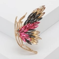 Squisita spilla a farfalla con cristalli colorati e cornice dorata su supporto bianco - Colorato