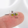 Silver double heart ear cartilage stud with yellow-green stones on a person's finger - Silver-Yellow Heart