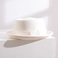 Chapeau pork pie élégant en laine blanche avec ruban sur un support minimaliste chic - Ivoire