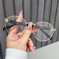 Detailed close-up of retro round metal glasses frame with gold finish and black temples - Gold Frame Clear