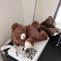 Cute brown plush teddy bear crossbody bag with beige strap on a decorative book - Brown Bear