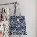 Detailed display of vintage paisley canvas tote bags hanging in three different colors - Navy Paisley