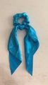 Elegant bright blue satin scrunchie with long ribbon bow on light wooden background - Shiny Satin Lake Blue