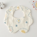 Detail of petal-shaped cotton baby bib featuring fried egg print and soft gauze texture - Gauze Flower Wrap - Egg Yolk Bear