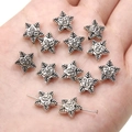 Detailed view of silver star-shaped alloy pendants with face design held in hand - Retro Pentagram / 11mm