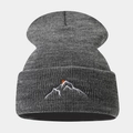 Dettaglio del ricamo con montagne e sole rosso su un berretto in maglia grigio scuro - grigio scuro