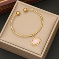 Close-up of golden open bangle featuring a pink enamel evil eye charm with sunburst rays - 4# Pink