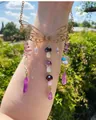 Detail of a butterfly suncatcher with purple crystals and mushroom charms in golden finish - Gold Wings + Amethyst