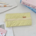 Close-up of yellow quilted pencil case with soft fabric texture and Sozakka woven label - Bright yellow
