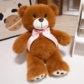 Brauner Plüsch-Teddybär mit rosa gepunkteter Schleife in warmer Wohnumgebung - Braun / 25cm
