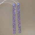 Detailed view of silver long fringe earrings featuring purple pavé rhinestones and Greek Key patterns - Purple