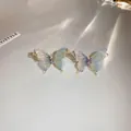Detalle macro de pendientes de mariposa con alas degradadas azules y cristales brillantes - Azul claro con pin de plata / Azul claro