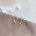 Silver bow earrings with rectangular purple gemstone drops on brown fabric surface - Bow Knot Purple Gem Dangle