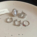 Close-up of diamond irregular flower rings and pearl earrings on a ceramic dish - Silver Flower 5-Piece Set