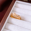 Primer plano de un anillo dorado ovalado con circonitas en un joyero de madera - Estilo de Banda de Eternidad / Dorado
