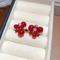 Macro shot of red pearl cluster earrings with sparkling zircon accents in a velvet box - Red (Real Gold Plated)