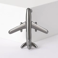 Macro detail of minimalist silver airplane brooch with a polished metallic finish - Gunmetal