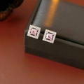 Macro detail of square pink zircon stud earrings set in silver on a black display box - Pink Style / Pink