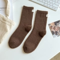 Deep brown plush crew socks with honey label for women in soft minimalist setting - One Size / Coffee