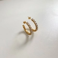 Detail of gold C-shaped earrings with clear zircon stones on a white background - White (DEK1083)