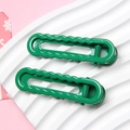 Pair of glossy macaron green wavy hair clips on a white ceramic tray with pink background - Christmas Green